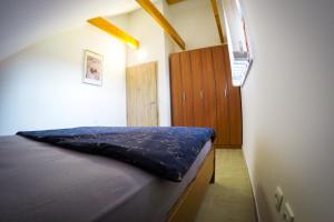 a bedroom with a bed and a wooden cabinet at APARTMA NIKA in Ribnica na Pohorju