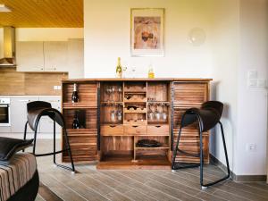 a kitchen with a wooden cabinet with wine glasses at APARTMA NIKA in Ribnica na Pohorju