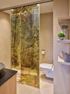 a bathroom with a toilet and a glass shower door at Appartementhaus Holmernhof I in Bad Füssing