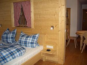 a room with a bed with blue pillows and a window at Huberbauernhof Ferienwohnungen in Piding