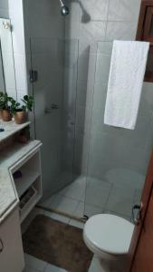 a bathroom with a glass shower with a toilet at Condomínio Encantador Piscina e Praia E12 in Zumbi