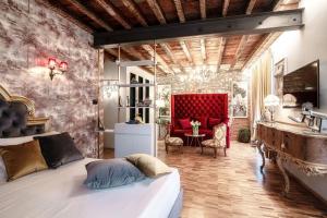 a bedroom with a bed and a red chair at Aurum - Como Luxury Suites in Como