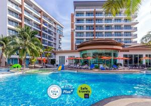 una piscina in un resort con un grande edificio di The Beach Boutique House a Kata Beach