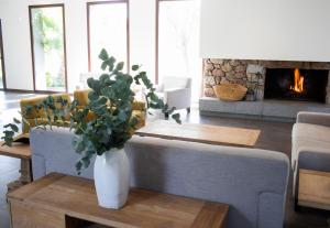 uma sala de estar com um vaso com uma planta sobre uma mesa em Hotel Rural Las Monteras em Villanueva del Rey