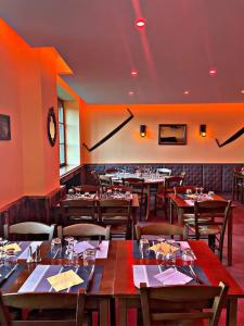 um restaurante com mesas e cadeiras e um relógio na parede em Auberge du Raddon em Raddon-et-Chapendu