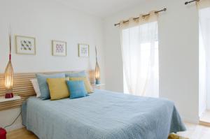 a bedroom with a bed with blue and yellow pillows at Lisbon Core Bairro Alto Chiado in Lisbon