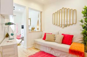 a living room with a white couch with red pillows at Lisbon Core Bairro Alto Chiado in Lisbon