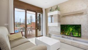 sala de estar con sofá y TV de pantalla plana en 2Pau - Lloret de Mar, en Lloret de Mar