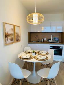 eine Küche mit einem weißen Tisch und Stühlen in der Unterkunft Hahnenklee Hills in Hahnenklee-Bockswiese