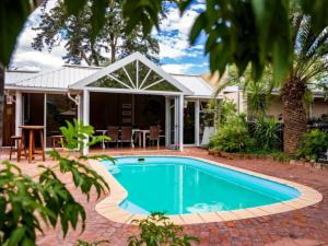 a swimming pool in front of a house at Londiningi Guesthouse in Windhoek +33 photos