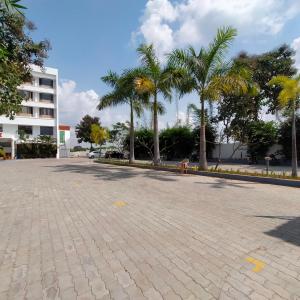 ein Parkplatz mit Palmen und einem Gebäude in der Unterkunft JB Residency in Tiruchchirāppalli