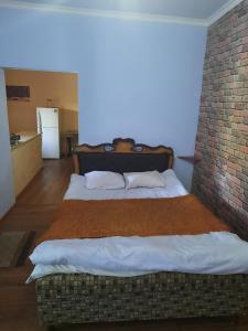 2 Betten in einem Zimmer mit Ziegelwand in der Unterkunft Family in Dilidschan