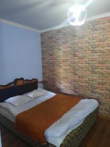 1 Schlafzimmer mit 2 Betten und Ziegelwand in der Unterkunft Family in Dilidschan