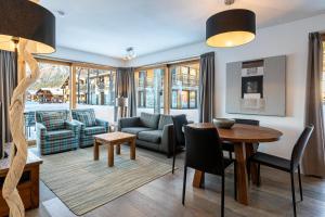 a living room with a table and chairs at FranceComfort - AlpResort Portes du Soleil in La Chapelle-dʼAbondance