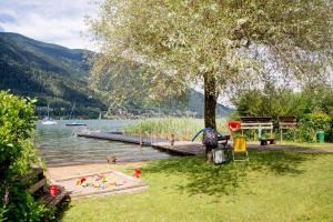 ein Park mit einem Dock und einem Wasserkörper in der Unterkunft LA7 Seeblick Appartement Haus Landskron direkt am Ossiachersee in Landskron