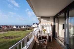 a balcony with a table and chairs and a view at Lichtblick im Haus Cäcilia in Wenningstedt
