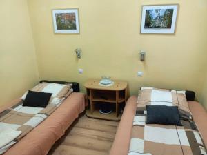 two beds in a room with a small table at Motel Sportowy OSiR Jawor in Jawor