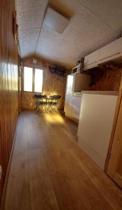 a room with a kitchen and a table in it at Petit chalet Valfréjus pied des pistes in Modane