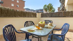 a blue table with chairs and a basket of fruit at 2P-51 - Lloret de Mar in Lloret de Mar