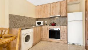 a kitchen with a washer and a white refrigerator at 2P-53 - Lloret de Mar in Lloret de Mar