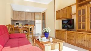 un salon avec un canapé rouge et une télévision dans l'établissement 2P-53 - Lloret de Mar, à Lloret de Mar