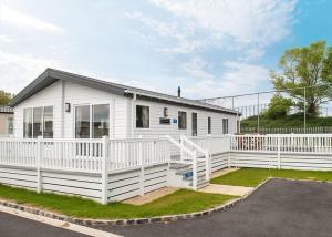 a white house with a white fence in front of it at Marine Holiday Park in Rhyl