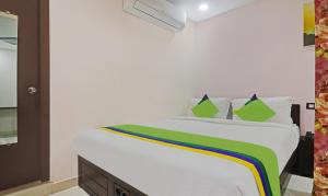 una camera da letto con un letto bianco con cuscini verdi di Itsy Hotels J A Royal Suites Manikonda a Hyderabad Altre 20 foto