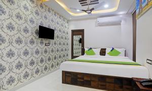 a bedroom with a bed and a tv on a wall at Treebo Trend J A Royal Suites Manikonda in Hyderabad