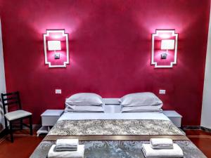 een slaapkamer met een bed en een rode muur bij NIK Rooms in Rome