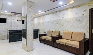 a waiting room with two chairs and a fireplace at Treebo Trend J A Royal Suites Manikonda in Hyderabad