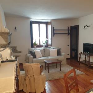 uma sala de estar com um sofá e uma mesa em Appartamento Dimora in Piazza -Locazione Turistica Santa Maria Maggiore em Santa Maria Maggiore