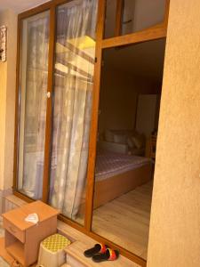 Habitación con puerta corredera de cristal y cama en Апартаментна 2 мин от плажа, en Ravda