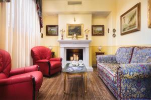Hotel San Gregorio في بينزا: غرفة معيشة مع كراسي حمراء ومدفأة