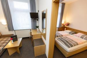 a hotel room with two beds and a mirror at Hotel Albena - garni Hotel in Fürstenwalde