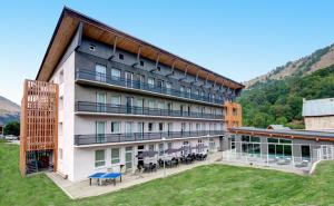 an apartment building with a courtyard with tables and chairs at Village Club La Pulka Galibier - Neaclub in Valloire