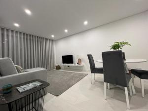 ein Wohnzimmer mit einem Sofa und einem Tisch in der Unterkunft Apartamento Prestige Tondela in Tondela