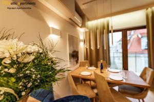 a dining room with a table with a vase of flowers at Baltic Apartments - Kormoran in Świnoujście