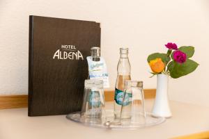 einen Tisch mit zwei Flaschen und eine Vase mit Blumen in der Unterkunft Hotel Albena - garni Hotel in Fürstenwalde