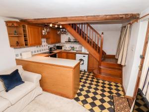eine kleine Küche mit einem Sofa und einer Treppe in der Unterkunft 5A Waterfall Way in Market Harborough