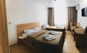 Habitación de hotel con 2 camas y toallas. en Bereg Anapy Guest House en Anapa