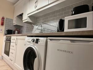 a kitchen with a washing machine and a microwave at 18 The Mullins in Donegal