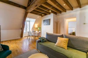 een woonkamer met een bank en een tafel bij LA Plume aux pieds du Parvis Saint Jean in Dijon