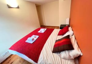 um quarto com uma cama grande e um cobertor vermelho em T2 au cœur du centre historique de Briançon #3 em Briançon