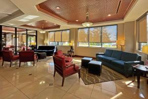 una sala de espera con sofás, sillas y ventanas en Comfort Suites Augusta Riverwatch, en Augusta