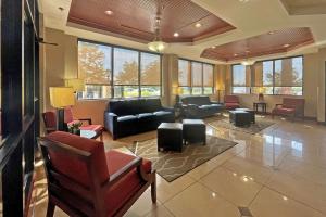 a living room with couches and chairs and windows at Comfort Suites Augusta Riverwatch in Augusta