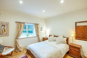 a white bedroom with a bed and a window at Penninghame Mid Lodge in Newton Stewart