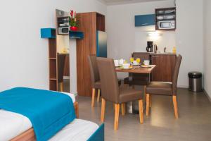 una habitación con mesa y sillas y un dormitorio en Odalys City Orléans Saint Jean, en Orléans