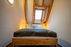 a bedroom with a bed with a window in the attic at Appartements Waldrose in Titisee-Neustadt