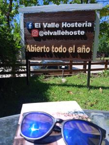une paire de lunettes de soleil assise sur une table devant un panneau dans l'établissement El Valle Hostería, à Mina Clavero