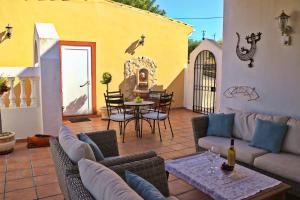 a patio with a couch and chairs and a table at Villa Santa Barbara by Portucasa in Bordeira